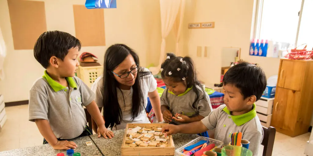 A woman and two children playing with a wooden toy.