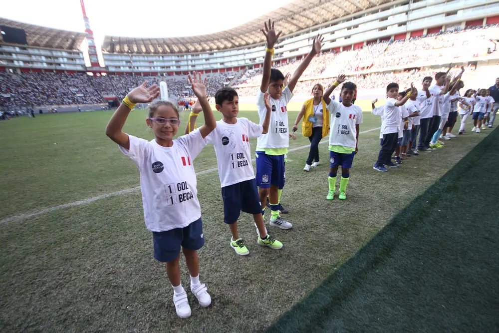 A group of young children standing on top of a field.