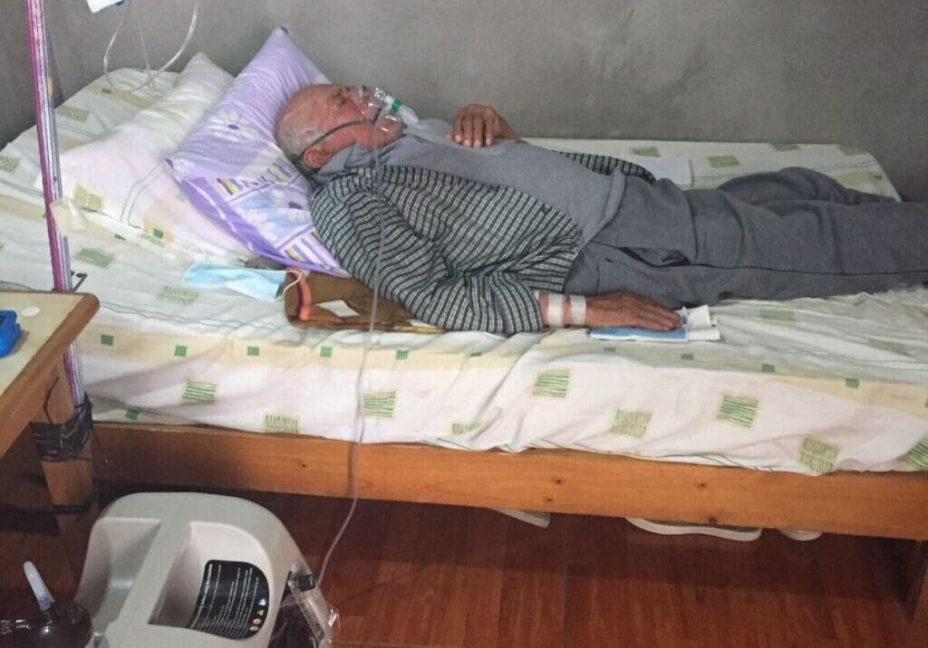 A man laying in bed with his head on the pillow.