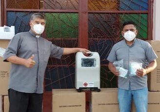 Two men wearing masks and standing next to boxes.