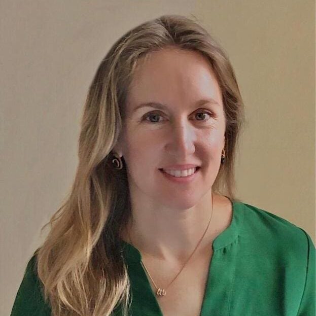 A woman in green shirt smiling for the camera.