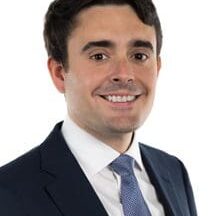 A man in suit and tie smiling for the camera.