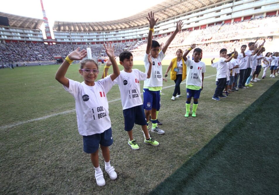 A group of young children standing on top of a field.